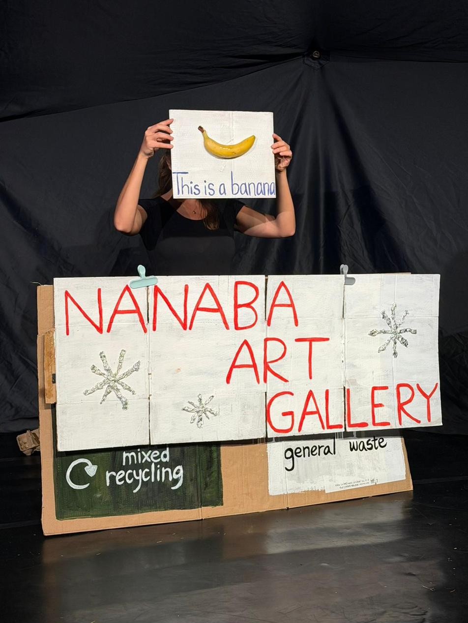 A mock art gallery scene built from waste: a banana presented as an artwork.